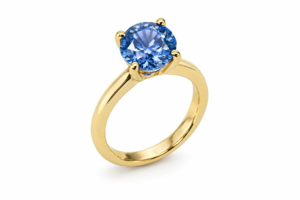 Round blue gemstone held by four slim gold claws on a plain yellow gold band