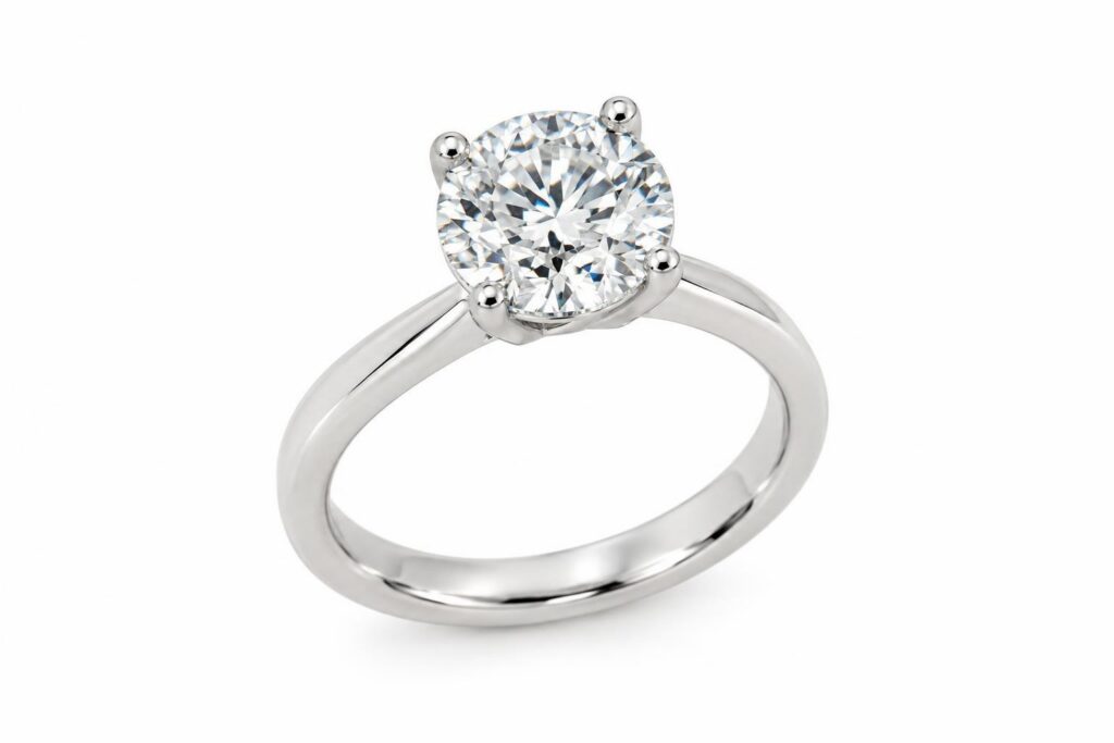 Solitaire ring with a round diamond held by four slim prongs, girdle visible between them